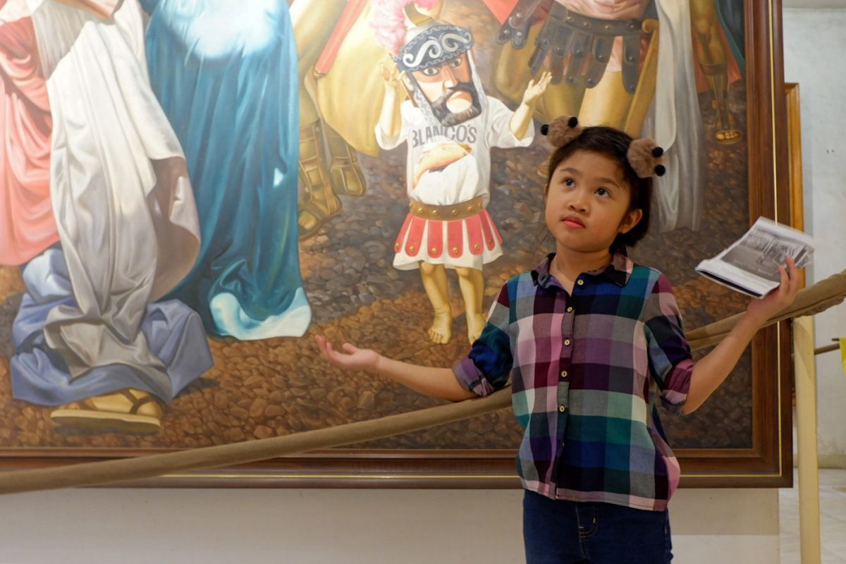 A young tourist mimics the young character in the painting.